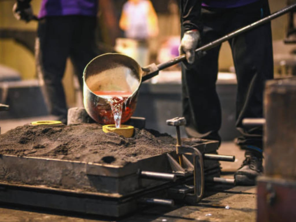 A foundry worker shaping molten metal.